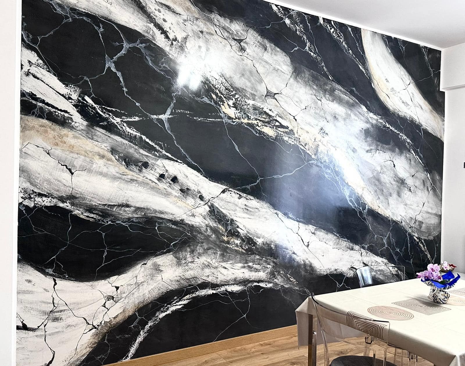 Una sala da pranzo con una parete in marmo bianco e nero