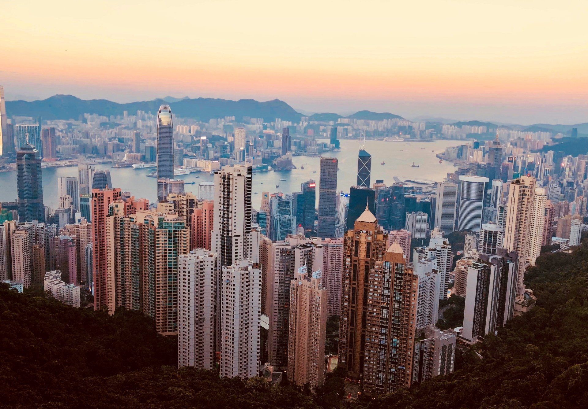 An aerial view of a city with a lot of buildings and mountains in the background.