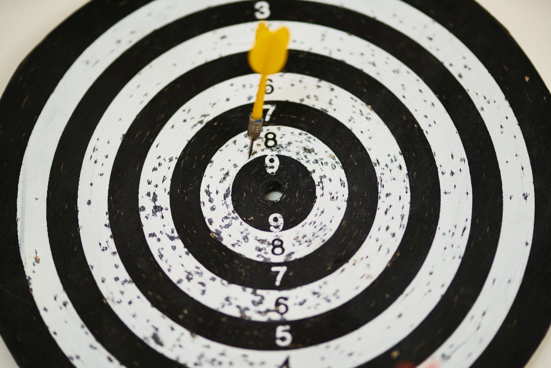 A dart board with a yellow dart in the center.
