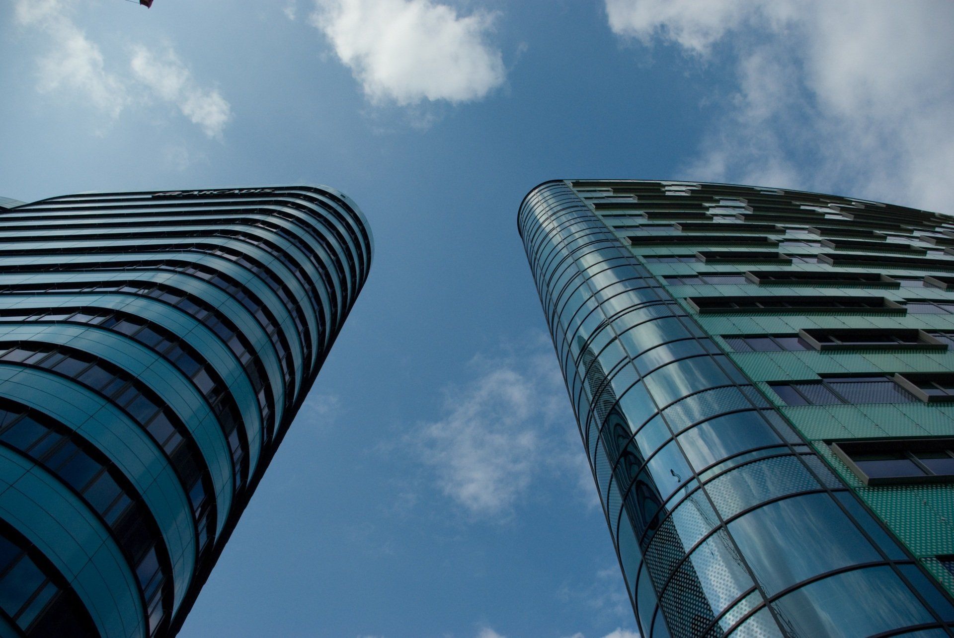 Looking up at two tall buildings against a blue sky.