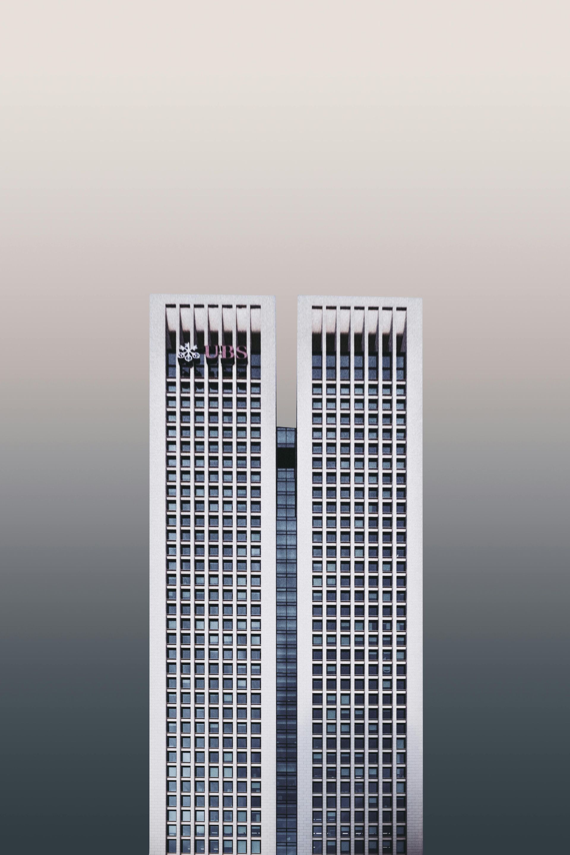 A couple of tall buildings against a cloudy sky.