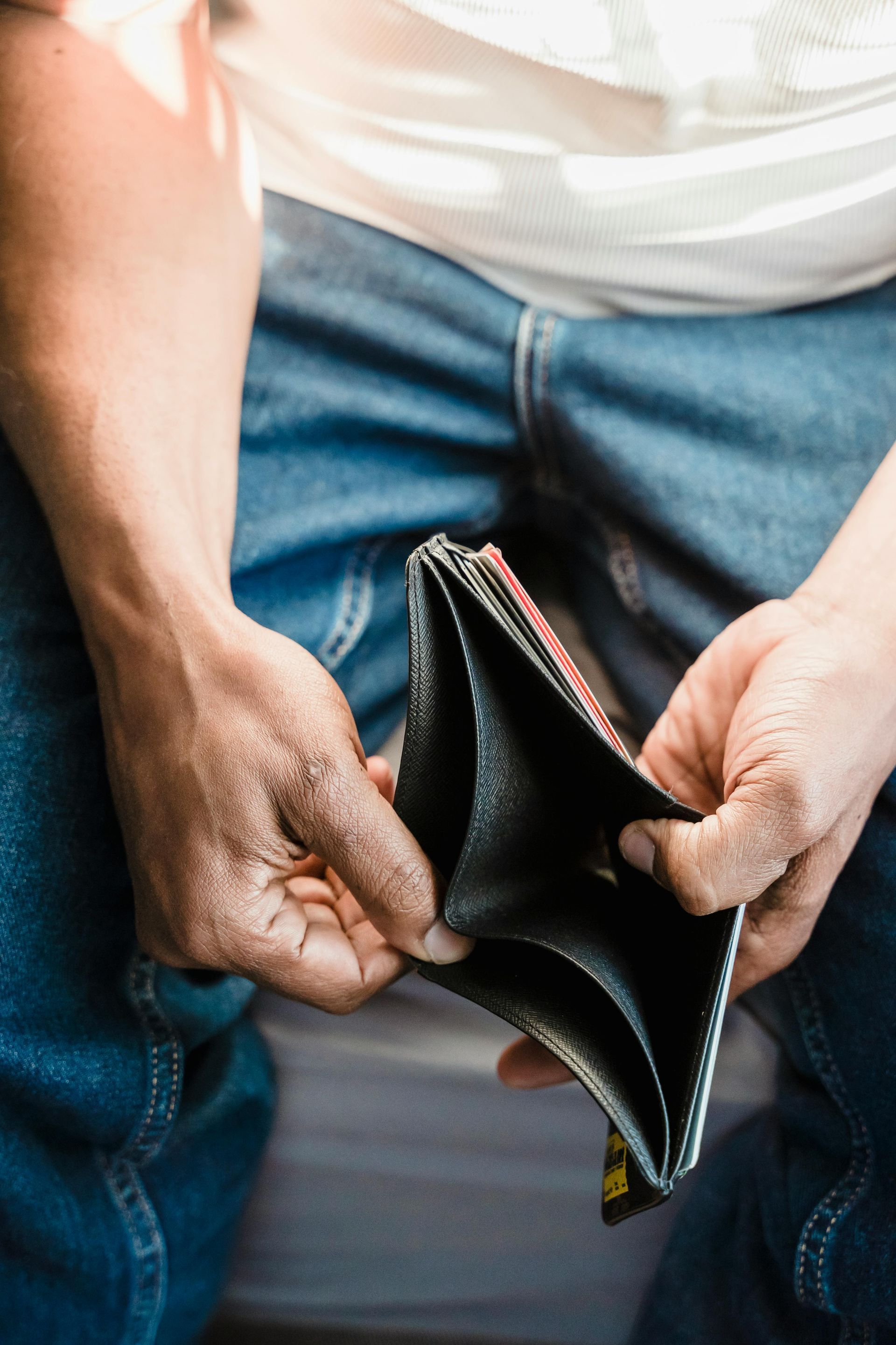 A man is holding an empty wallet in his hands.