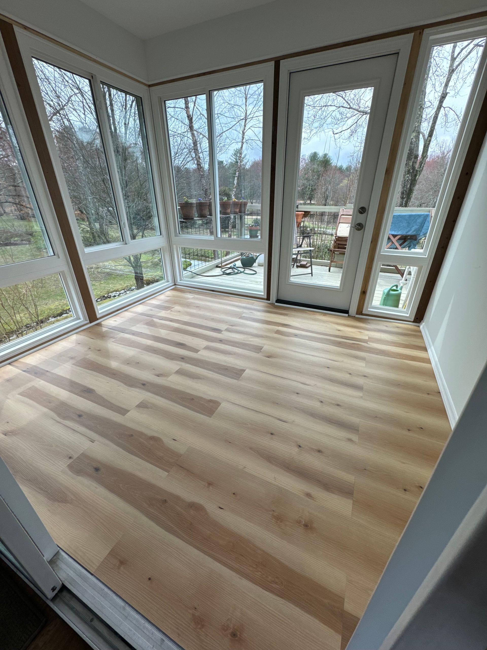 A room with hardwood floors and lots of windows