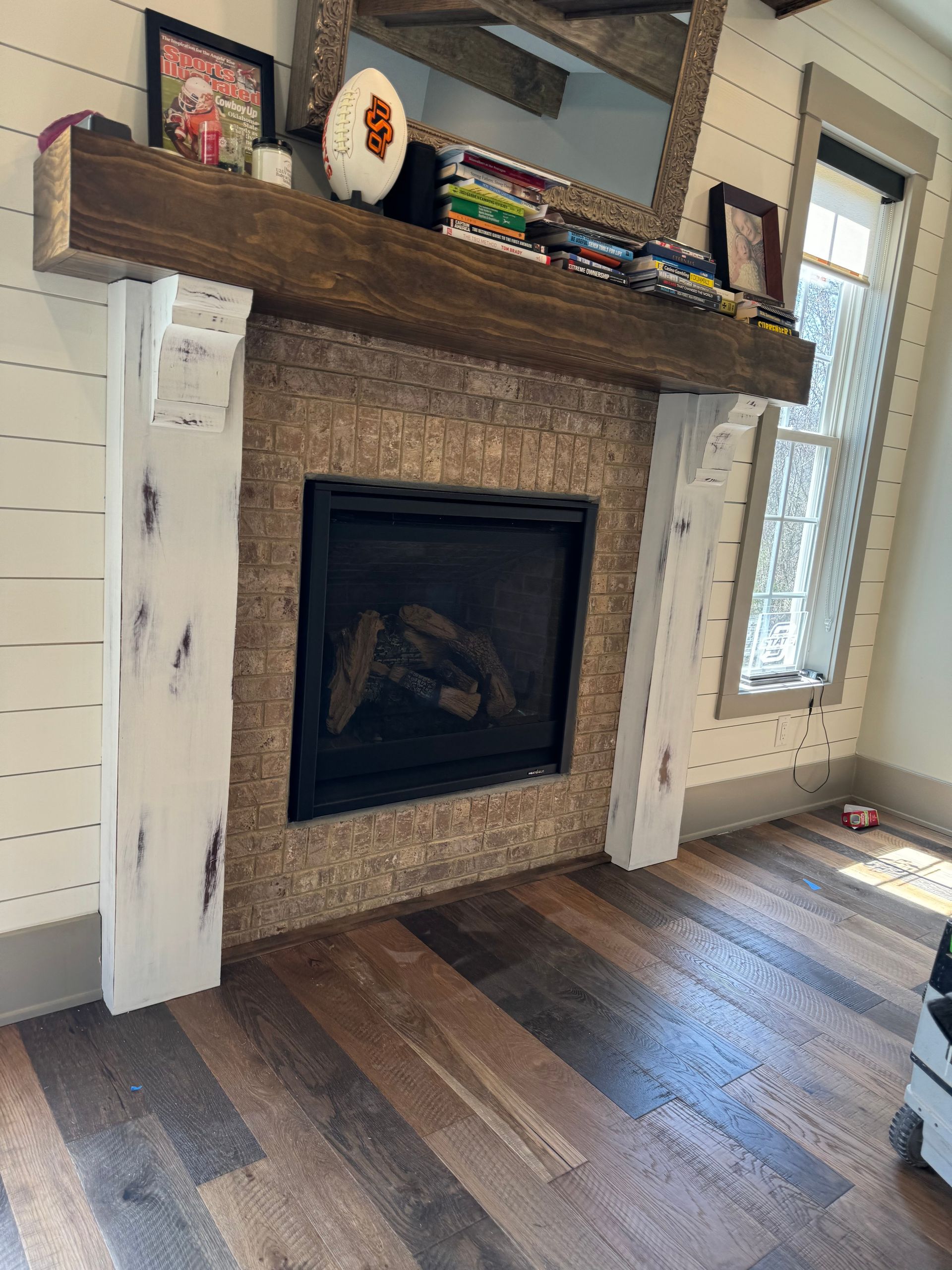 A living room with a fireplace and a wooden mantle.