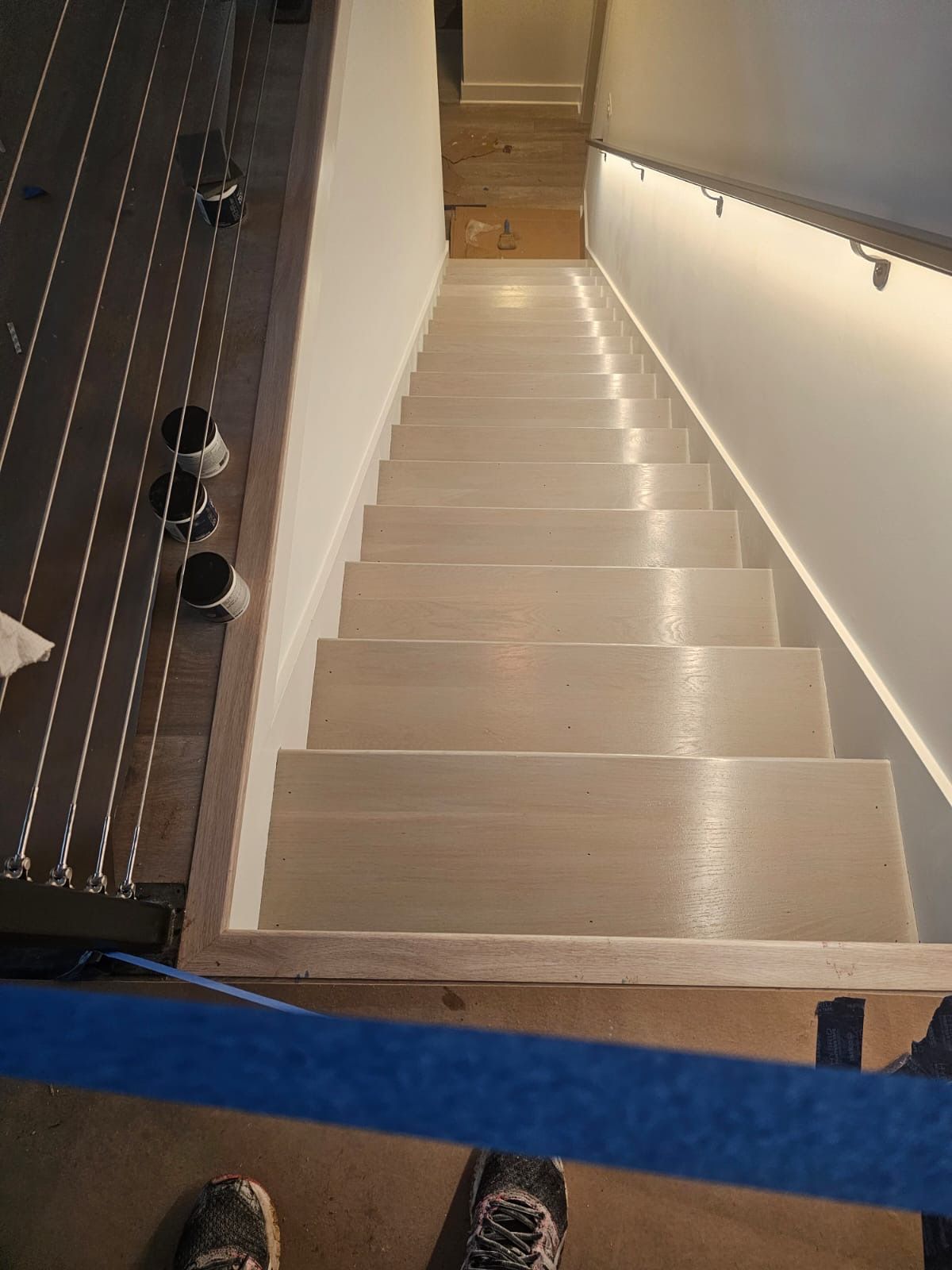 A person is standing on a set of stairs with a blue tape.