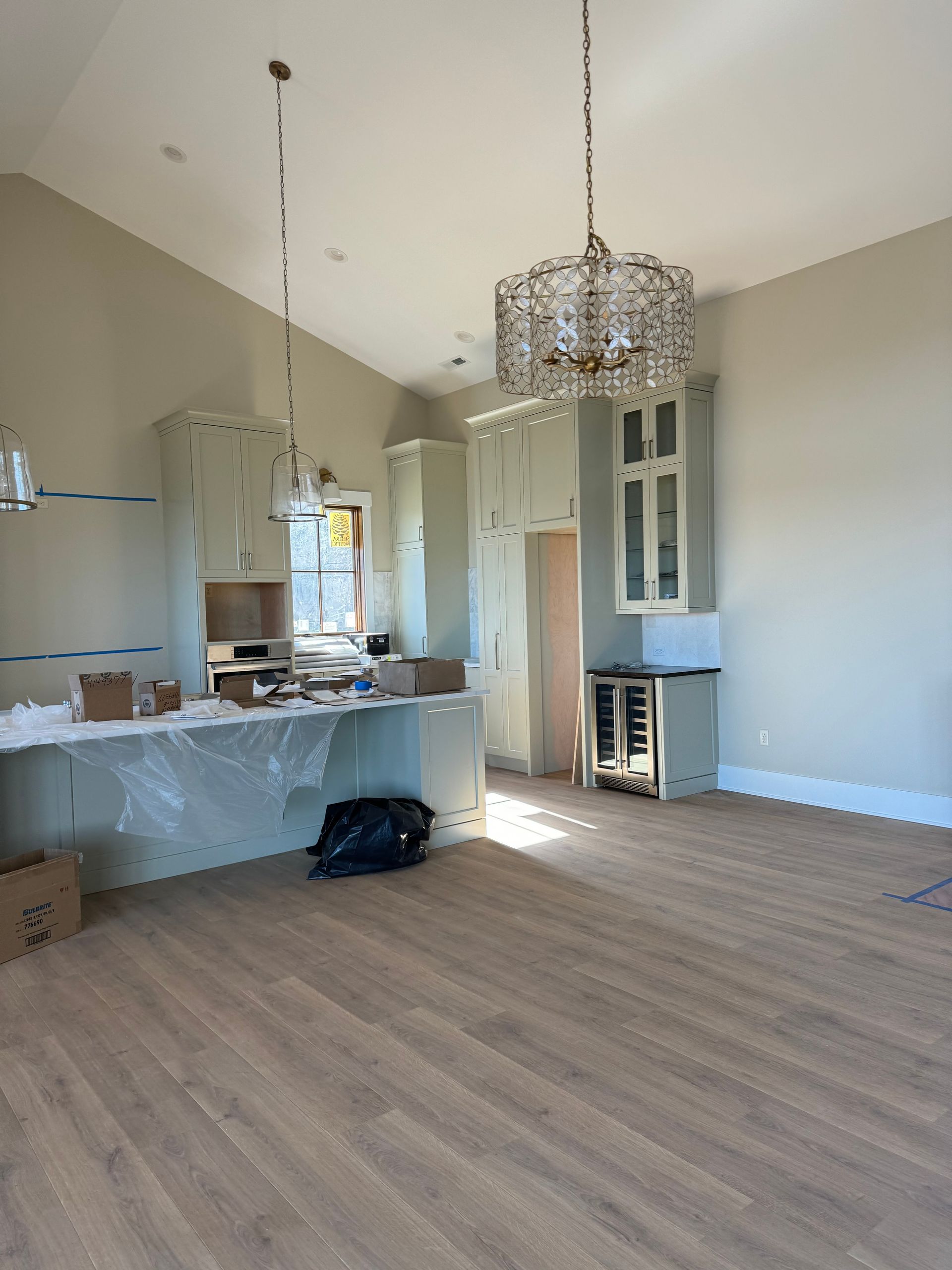 An empty kitchen with a chandelier hanging from the ceiling.