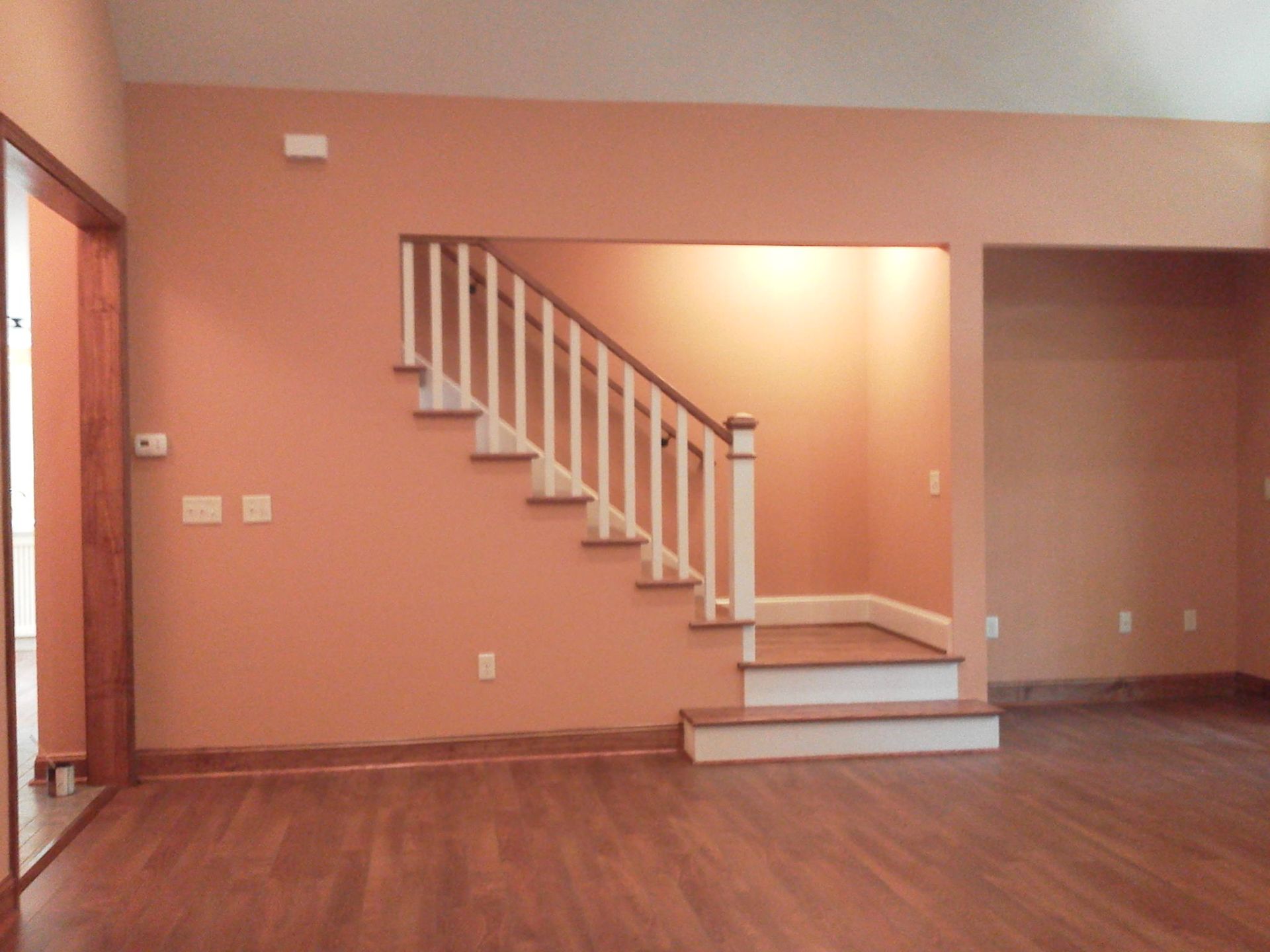 An empty room with a staircase leading up to the second floor