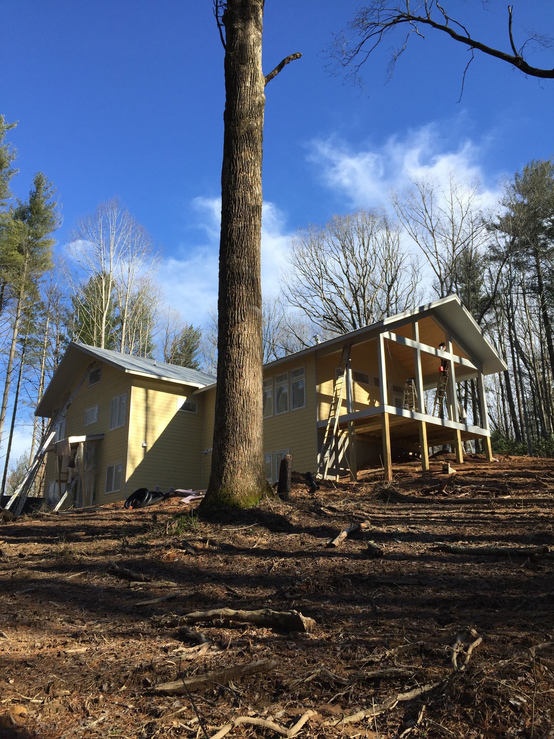 A house is sitting on top of a hill in the middle of a forest.