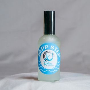 A small perfume bottle with a black lid and blue label that reads 