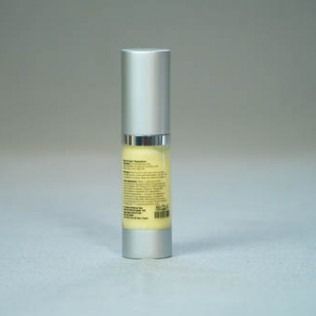 Silver and yellow skincare product bottle on a gray background.