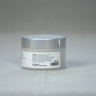 Small, silver-lidded jar of white cream. Product label visible.