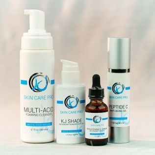 Four skincare product bottles: cleanser, sunscreen, serum, and anti-aging gel with the same logo.