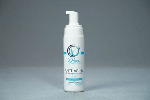 White bottle of anti-aging foaming cleanser with a pump. Contains a blue and black label.