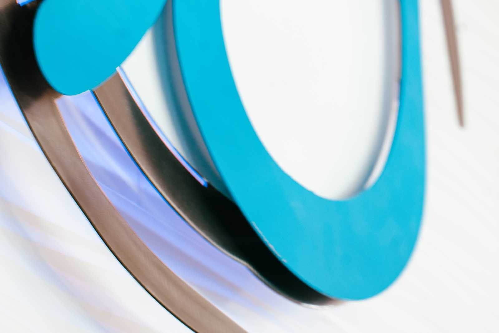 Abstract design: blue and silver layered circles on a white background, creating a three-dimensional effect.