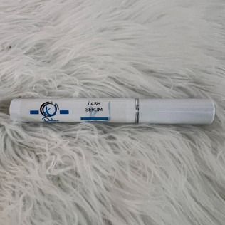 White tube of lash serum on a fluffy, white surface; 