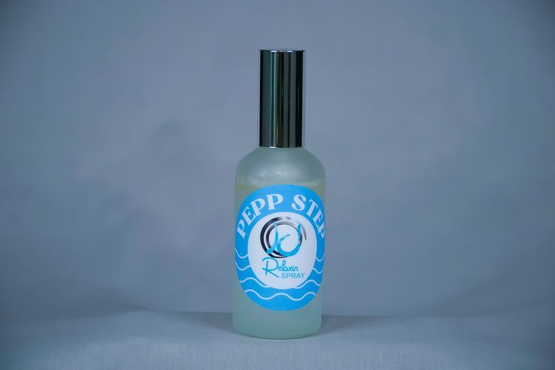 A small perfume bottle with a black lid and blue label that reads 