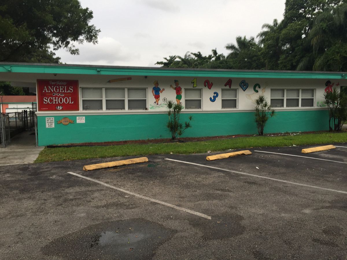 A green and white building with a sign that says angels school
