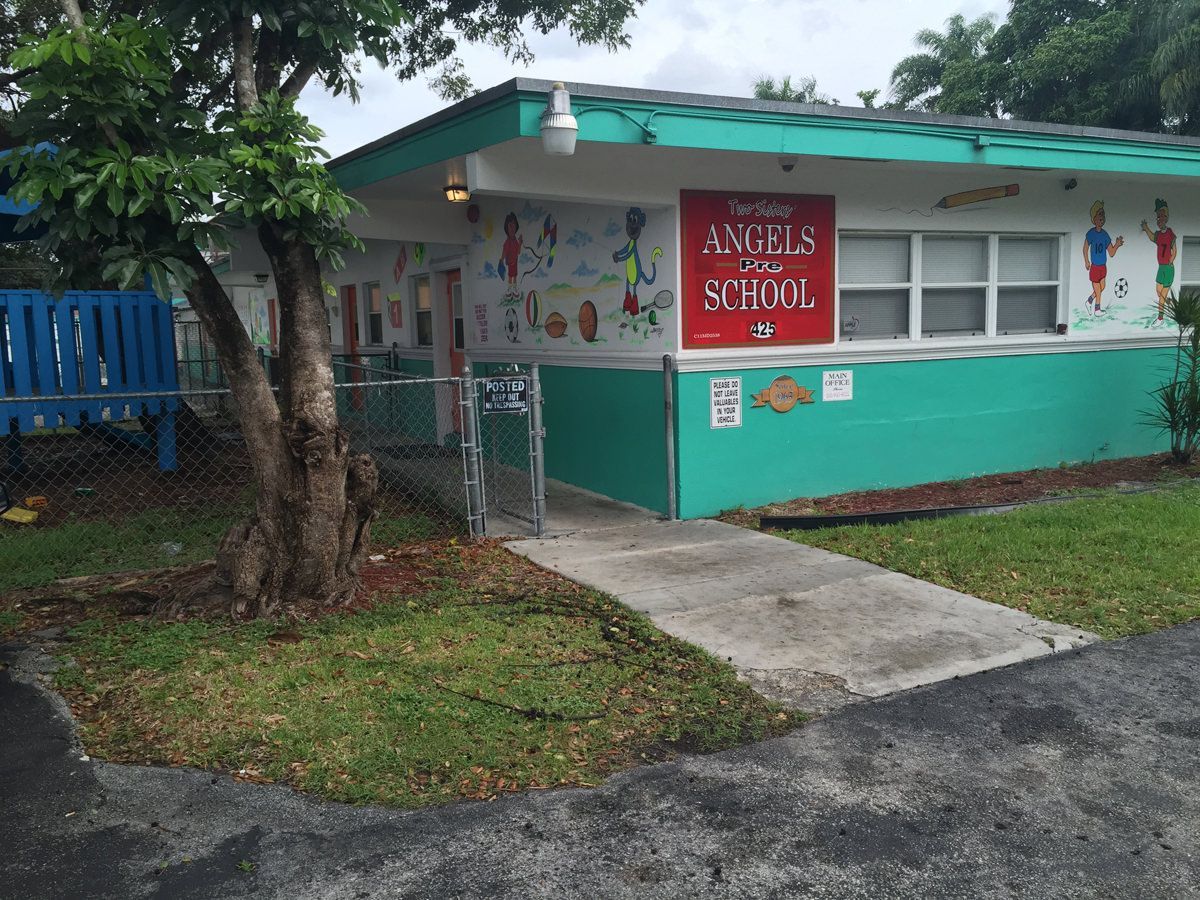 A green and white building with a red sign that says ave 's school