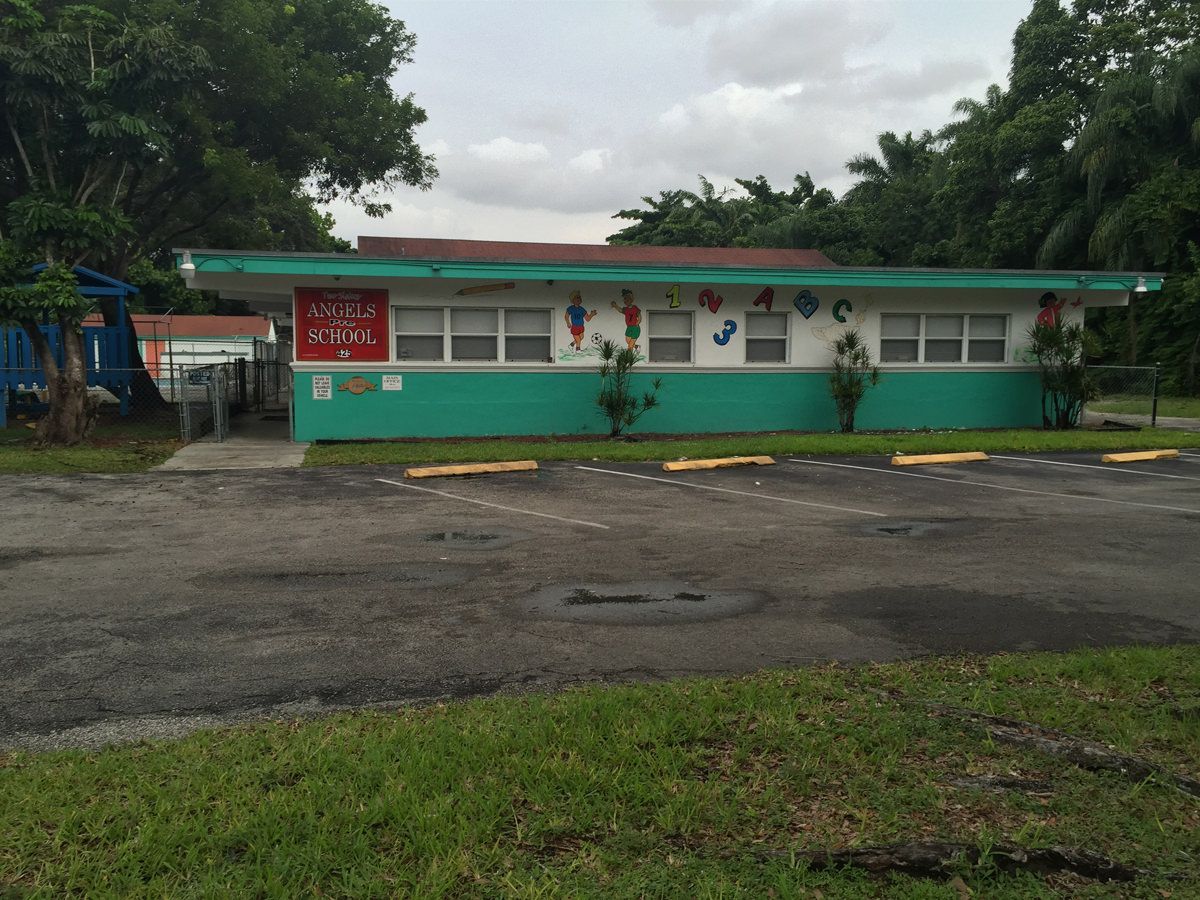 A green and white building with a red roof
