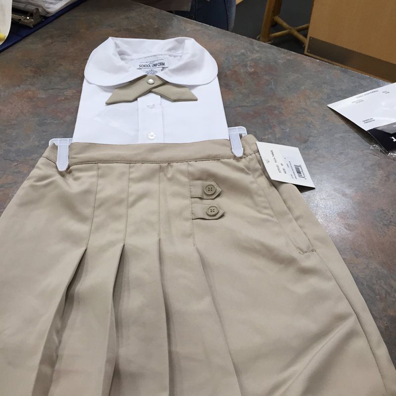 A white shirt and khaki skirt are on a table