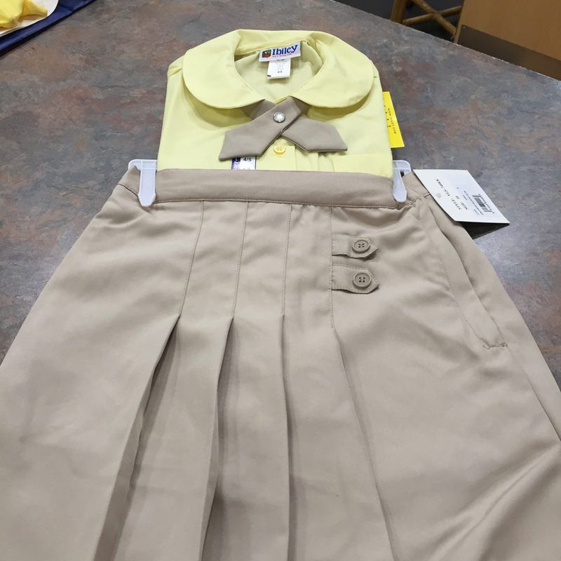 A yellow shirt and khaki skirt are on a table