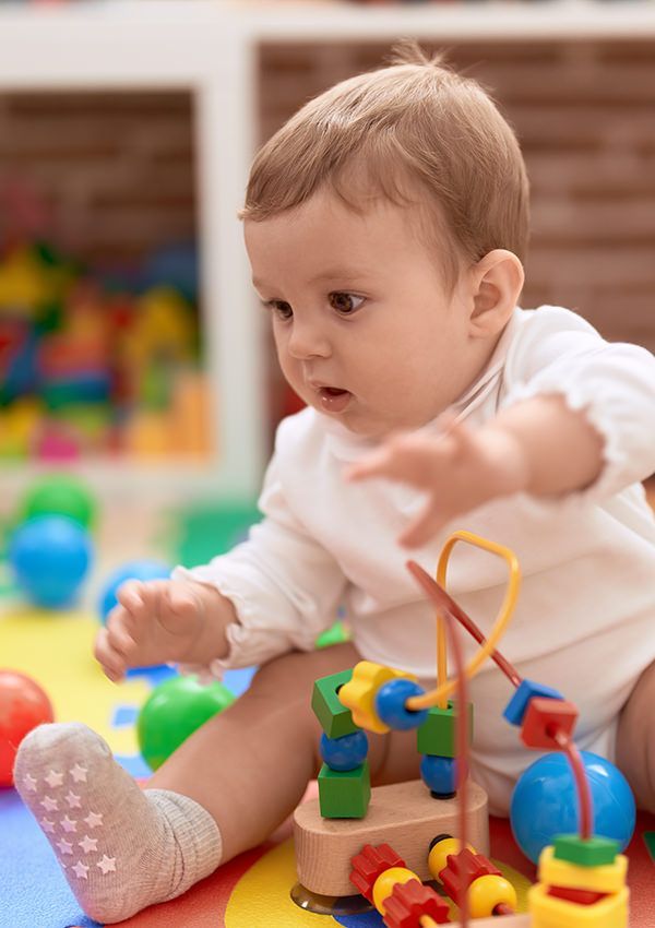 A baby is sitting on the floor playing with toys.