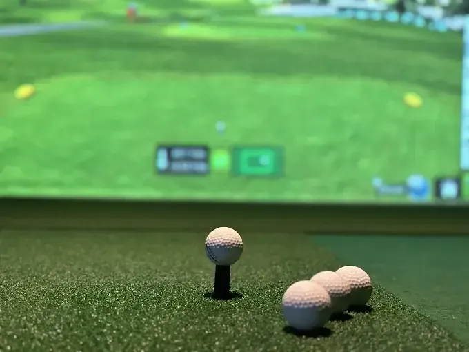 Golf ball on green grass with club.