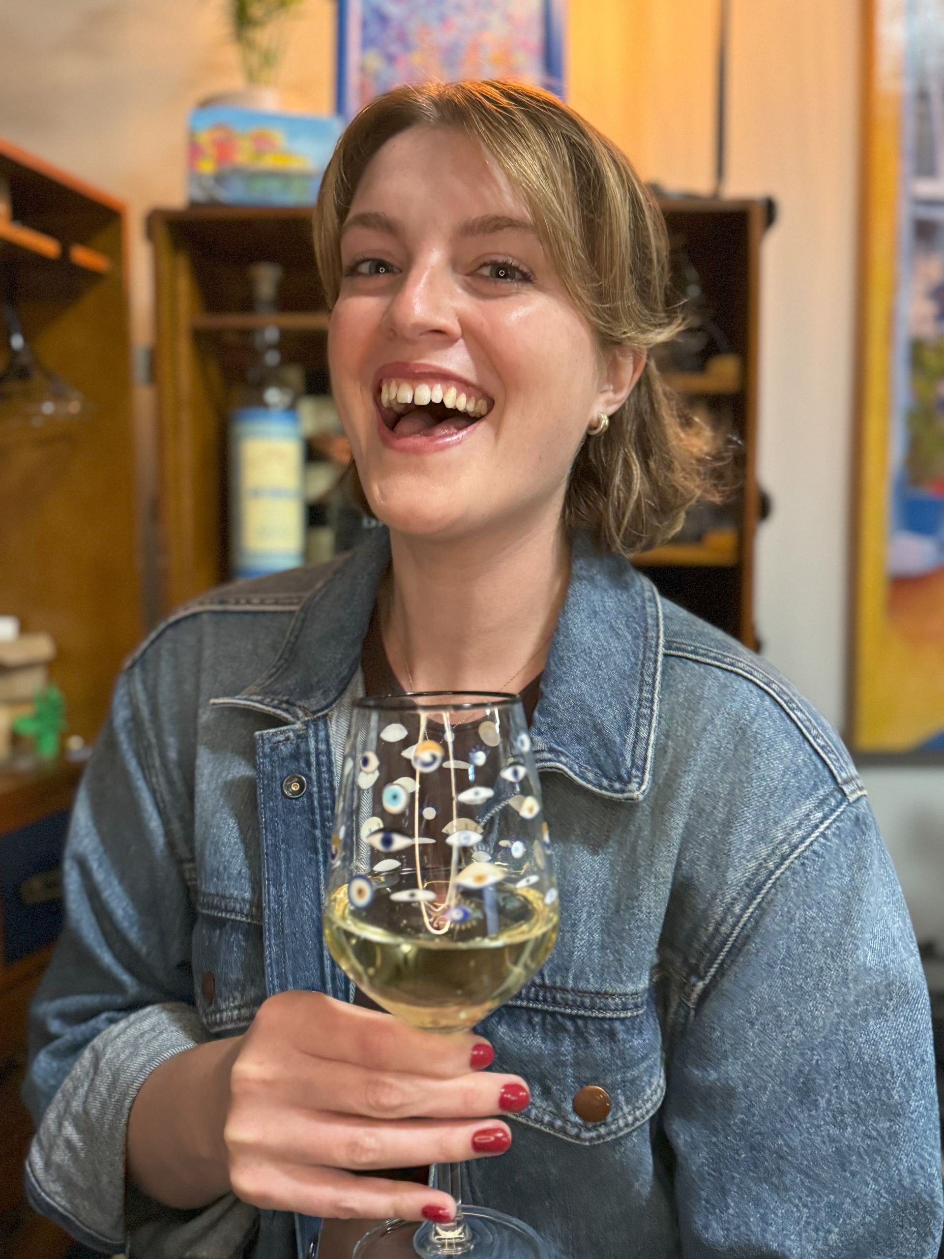 No Wine Left Behind’s creative partner smiling with a glass of white wine.