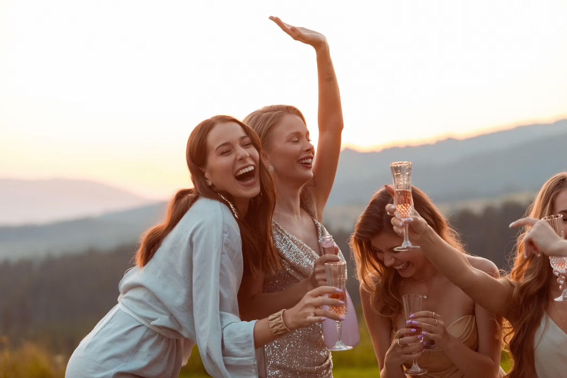 Bride and friends at a bachelorette party, smiling around a dessert table with pink decorations