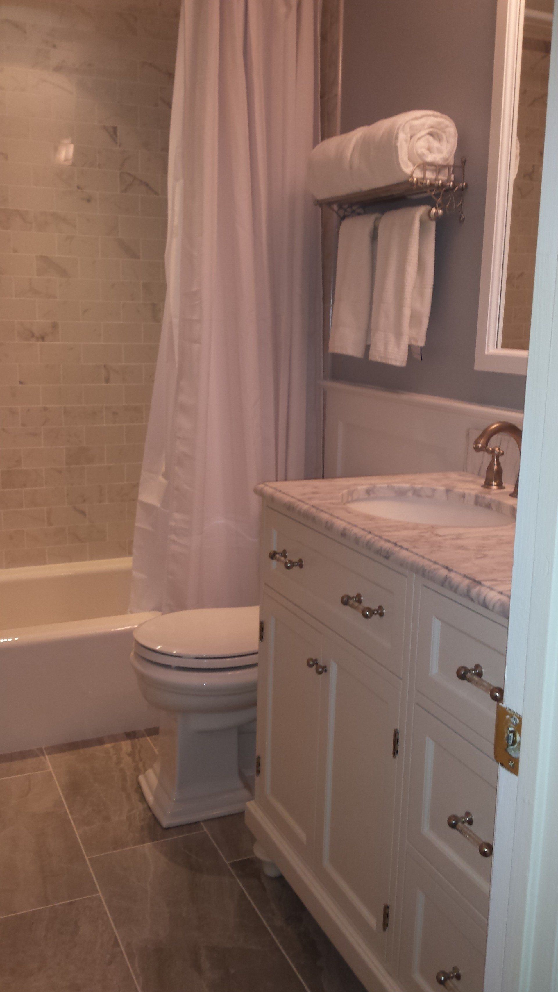 A bathroom with a toilet , sink , and bathtub.