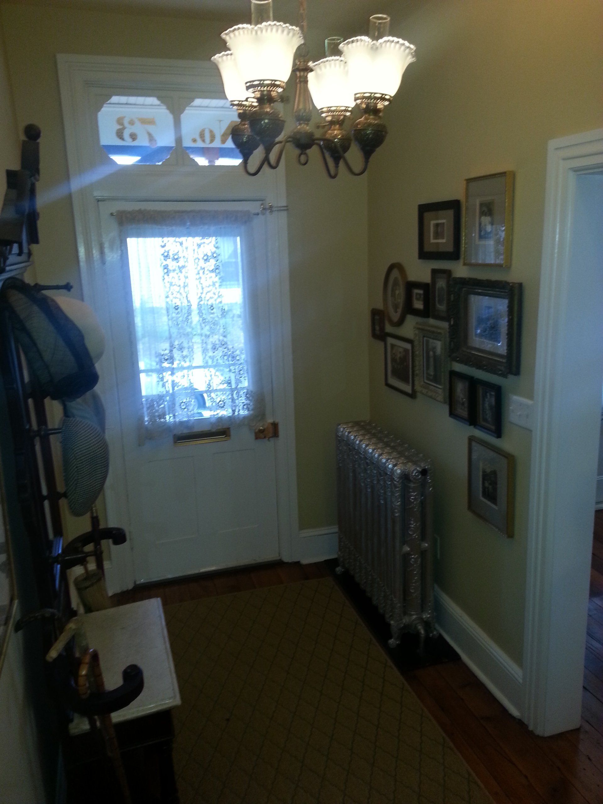 A hallway with pictures on the wall and a chandelier