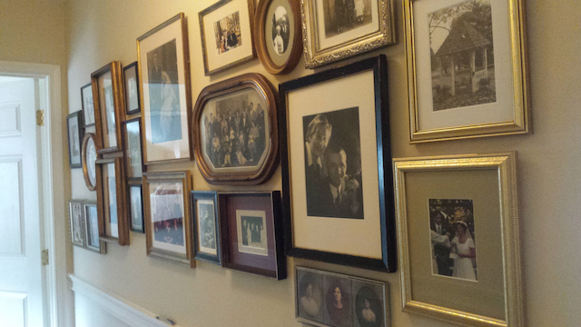 A hallway filled with lots of framed pictures on the wall.