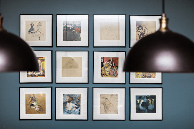 A wall with a bunch of framed pictures on it