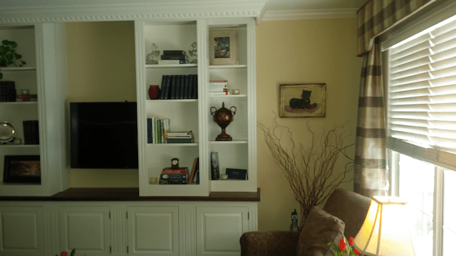 A living room with a couch and a television on the wall