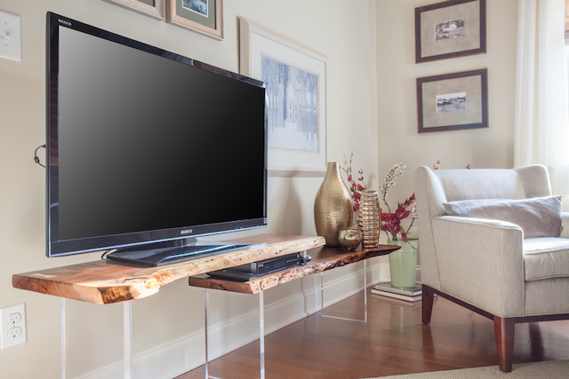 A living room with a flat screen tv on a wooden stand.