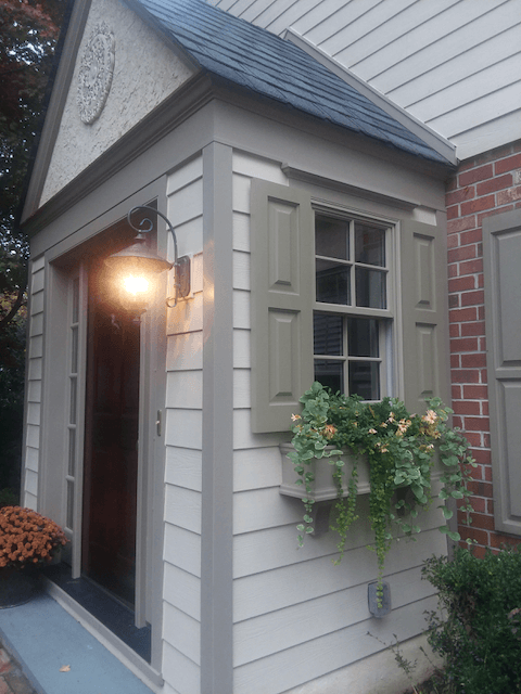 A house with a porch and a window with shutters