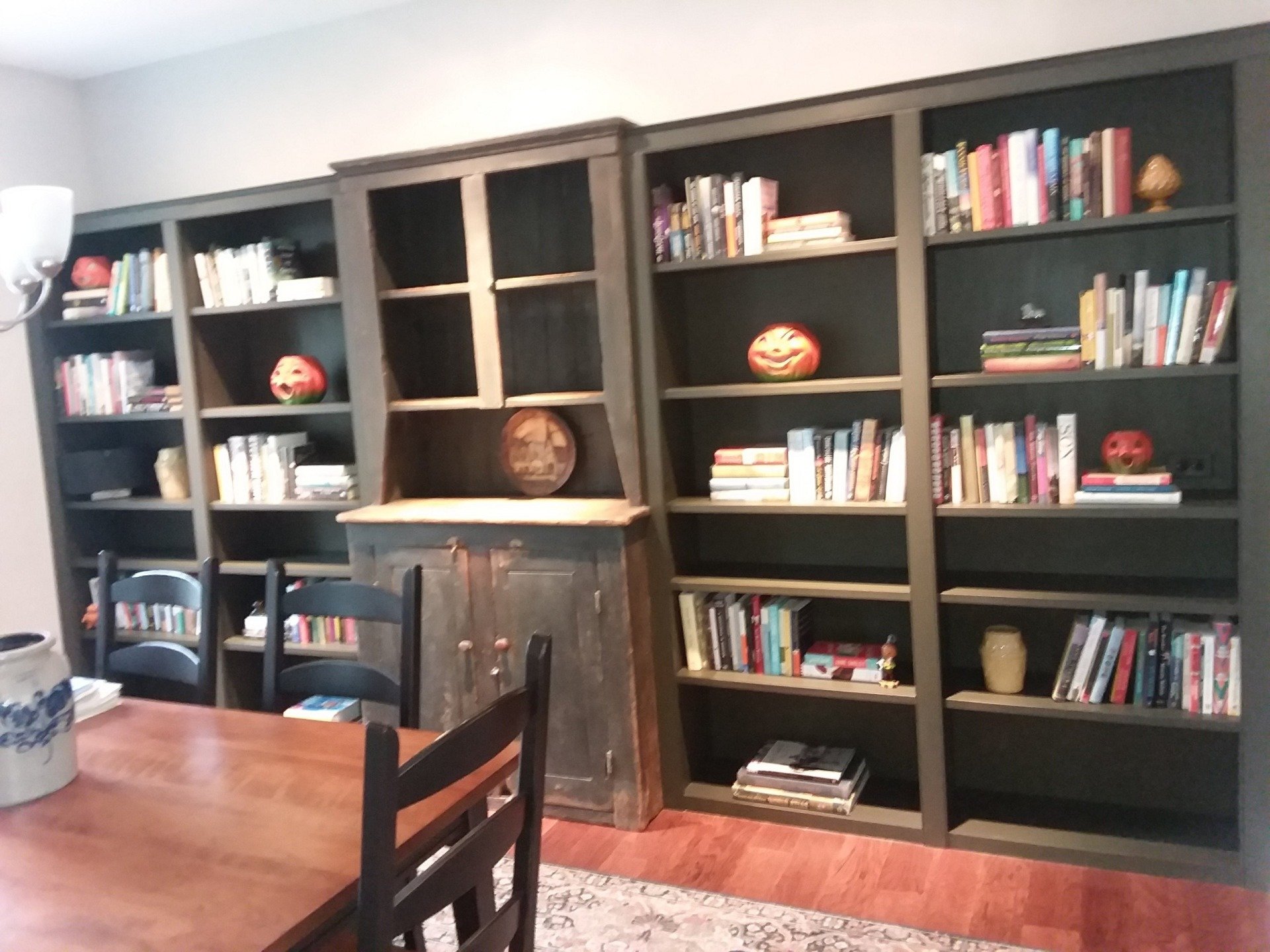A dining room with lots of bookshelves and a table