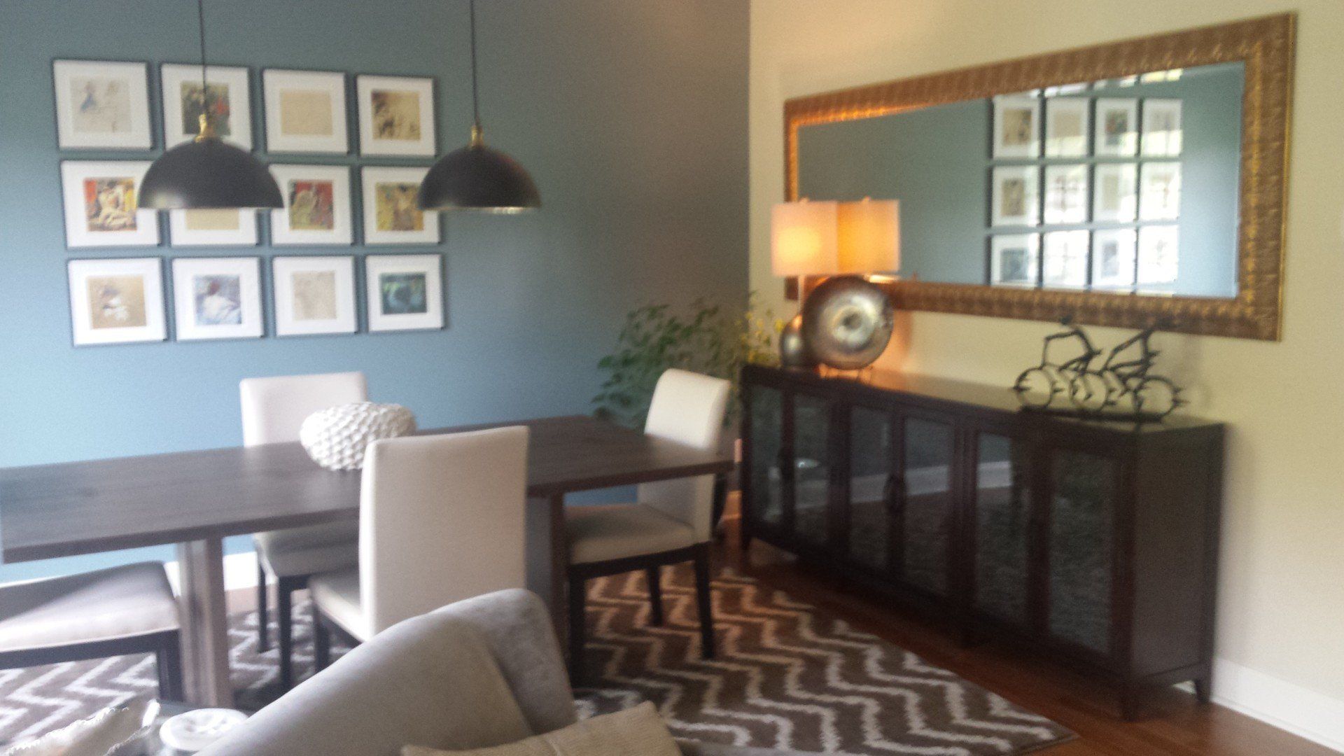 A living room with a table and chairs and a large mirror