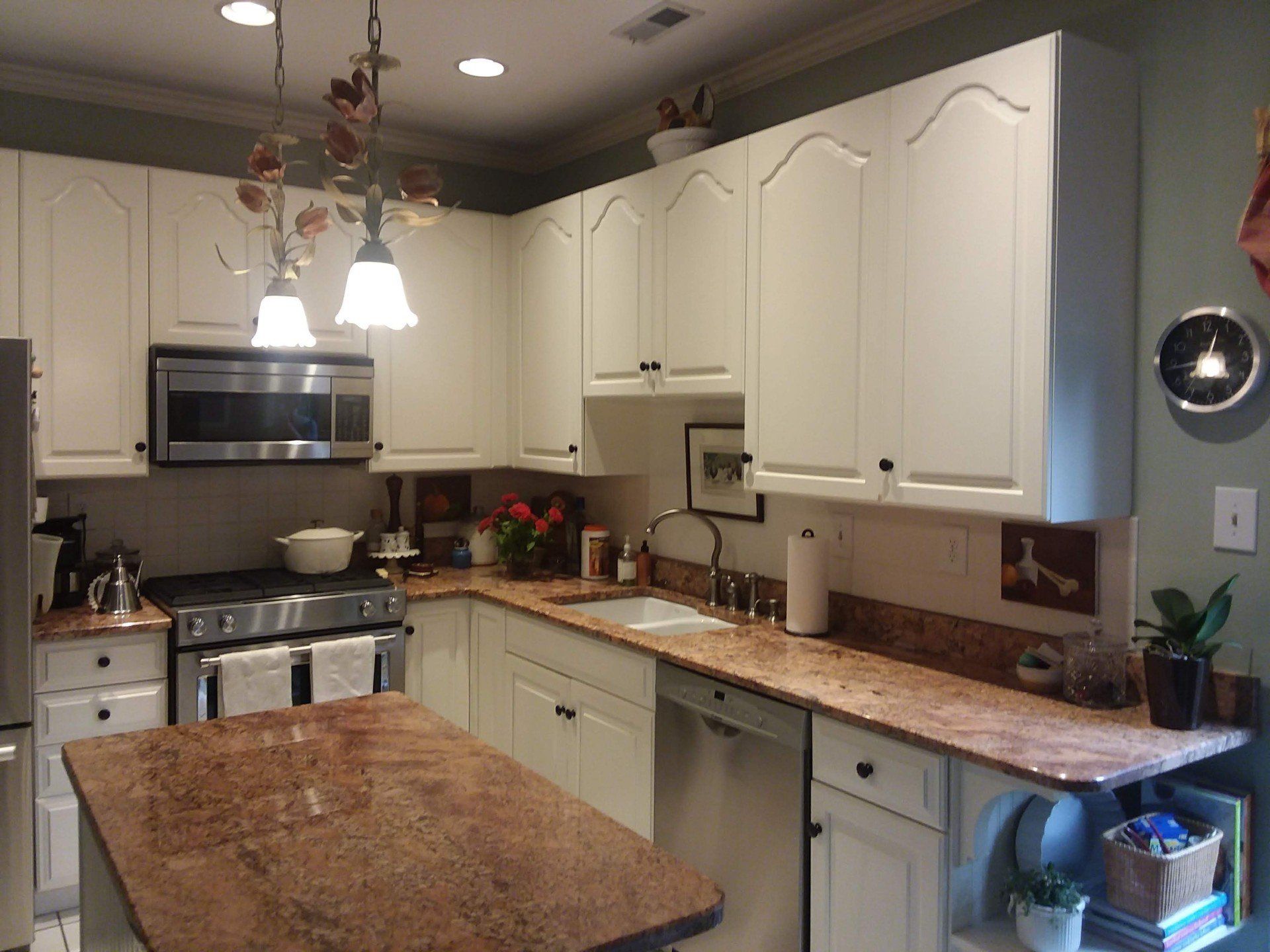 A kitchen with white cabinets and granite counter tops