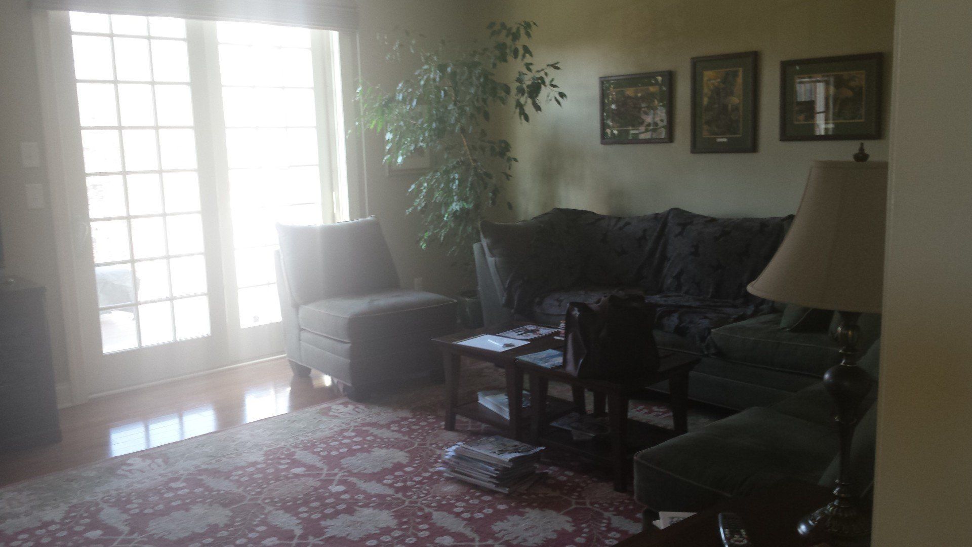 A living room with a couch , chair , table and lamp.