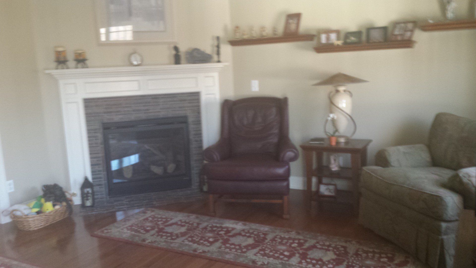 A living room with a fireplace , chair , couch and rug.