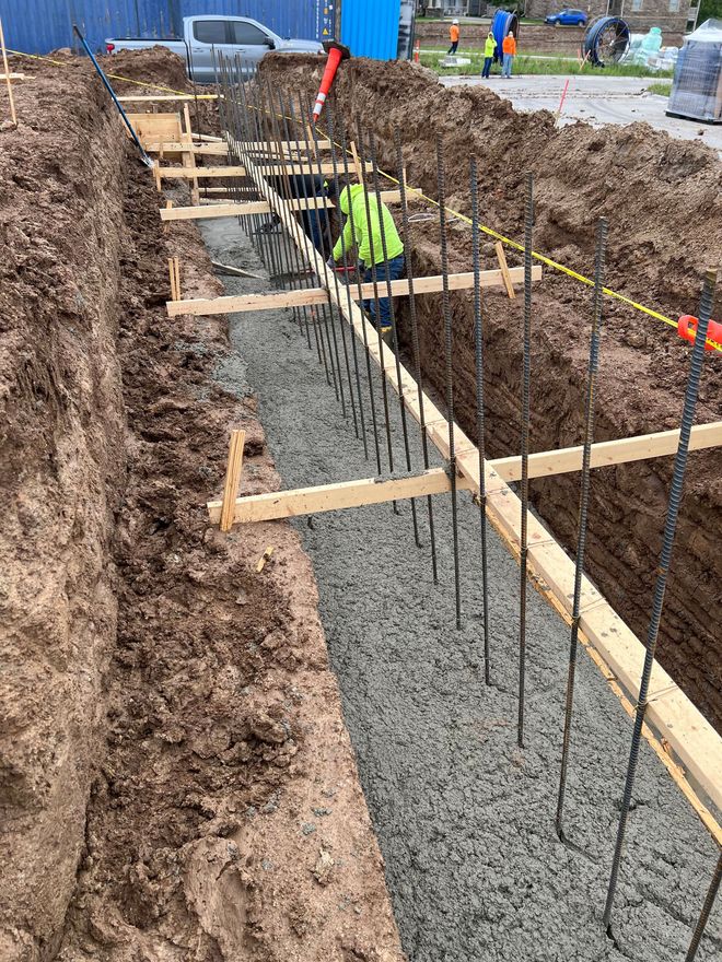 A construction worker is working on a concrete wall.