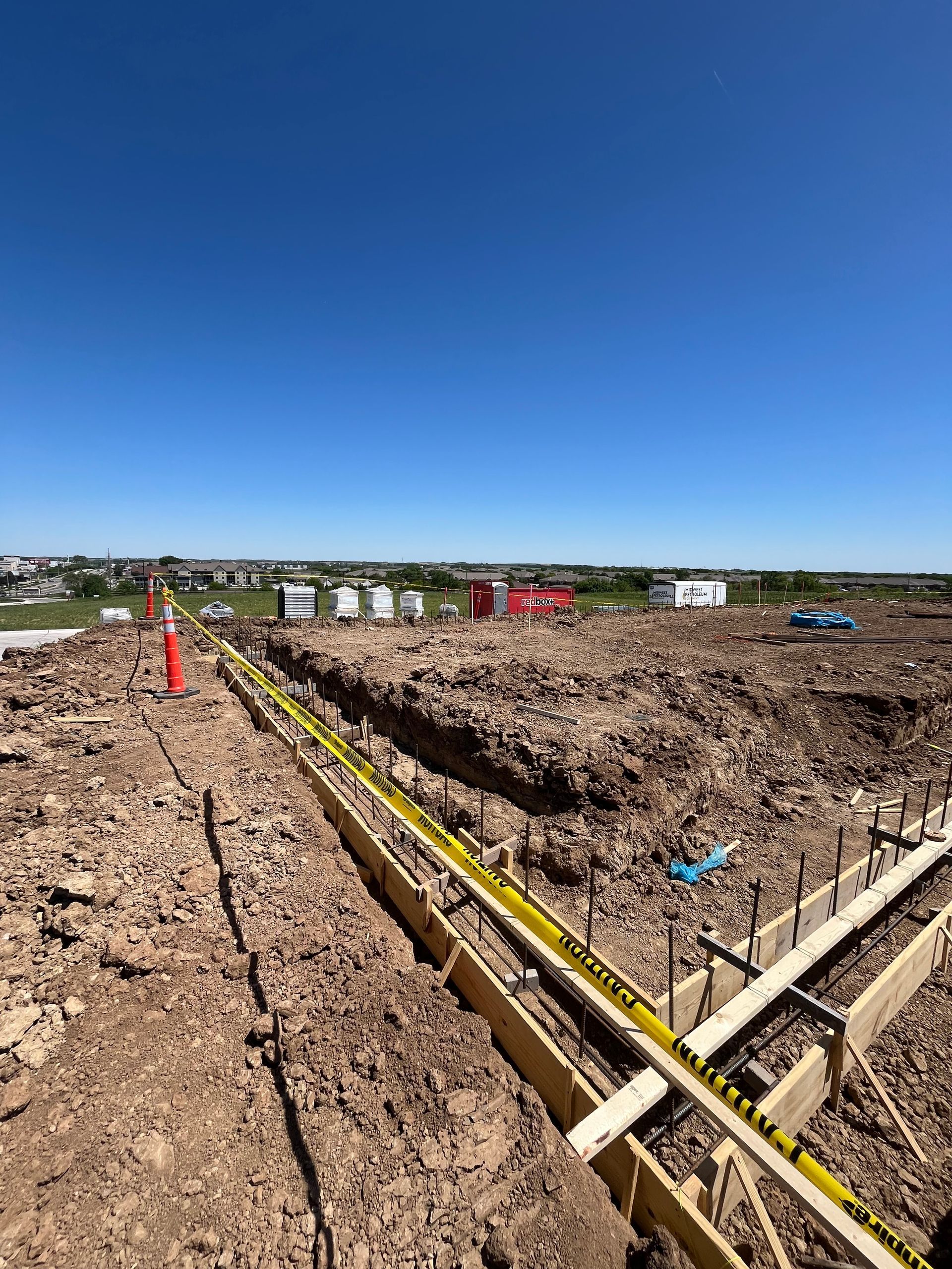 A construction site with a lot of dirt and a blue sky in the background.