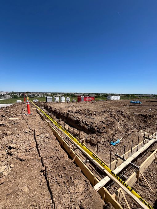 A construction site with a lot of dirt and a blue sky in the background.