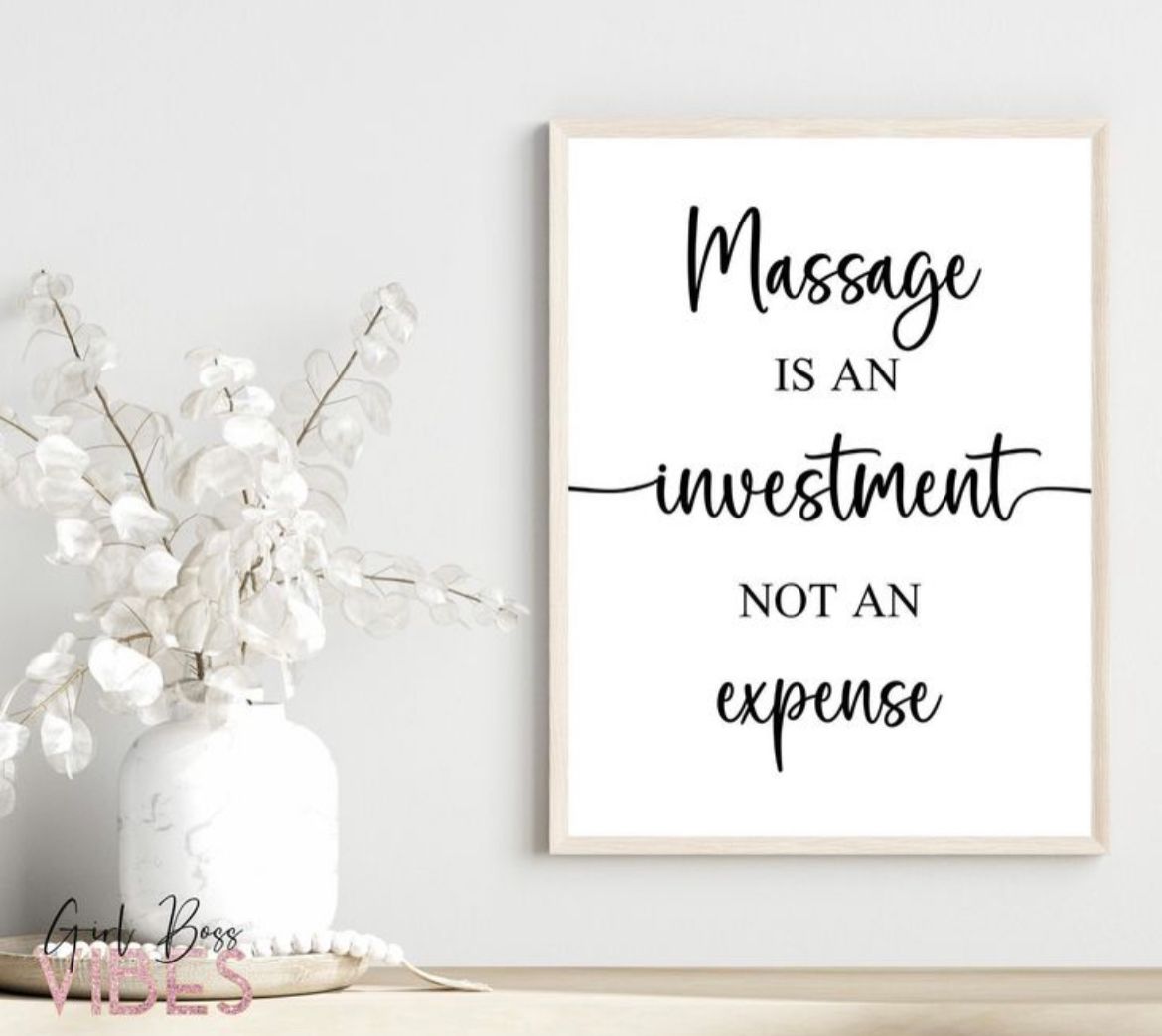 White framed quote print on a light wall beside a white vase with branches and flowers.