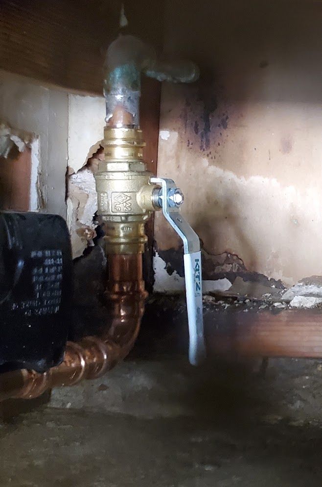 A close up of a copper pipe with a valve attached to it.