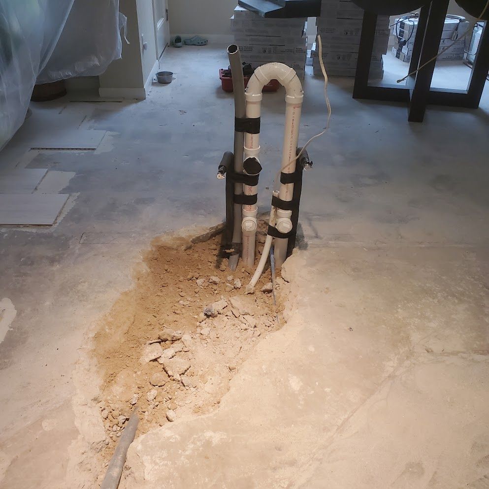 A hole in the floor with pipes coming out of it