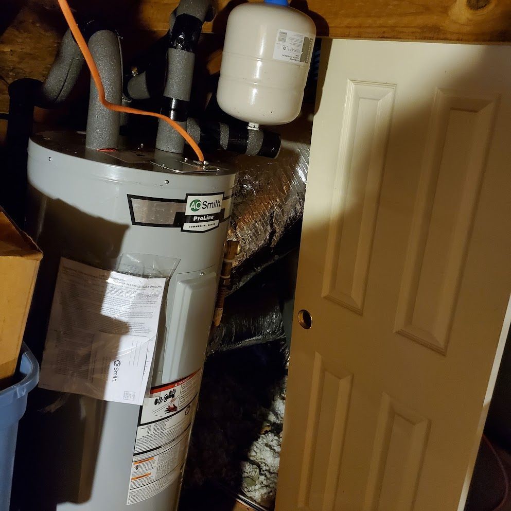 A water heater is sitting next to a door in a room.