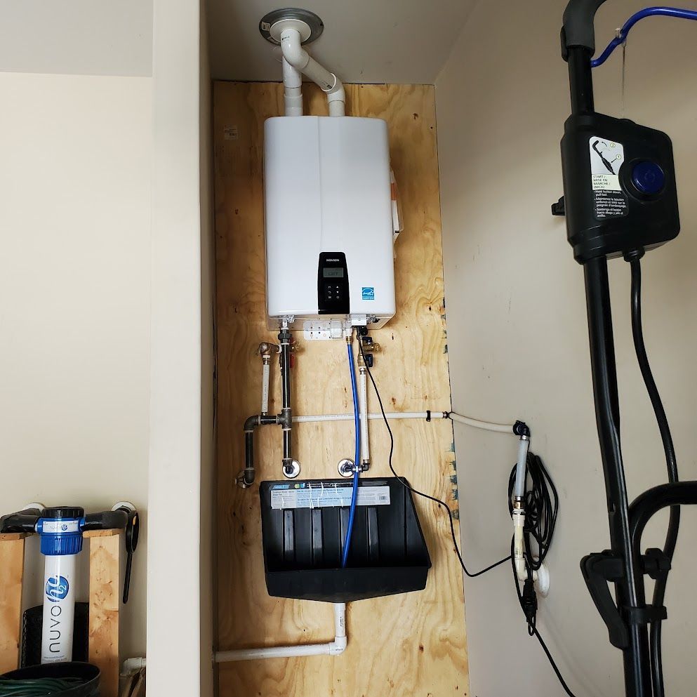 A white water heater is mounted to a wooden wall