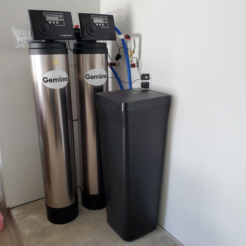 Two stainless steel water filters are sitting next to each other in a room.